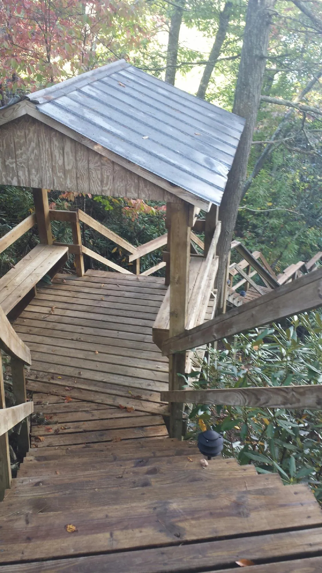 Metal roofed shelter over wooden steps on a wooded walkway — Skylight Repair & Installation work by our crew in Westminster